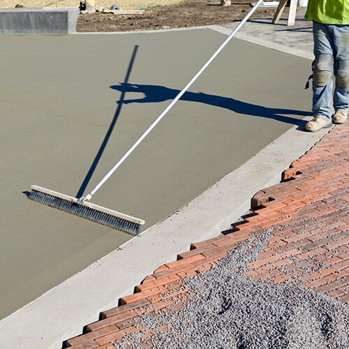 Concrete being poured over helical piles